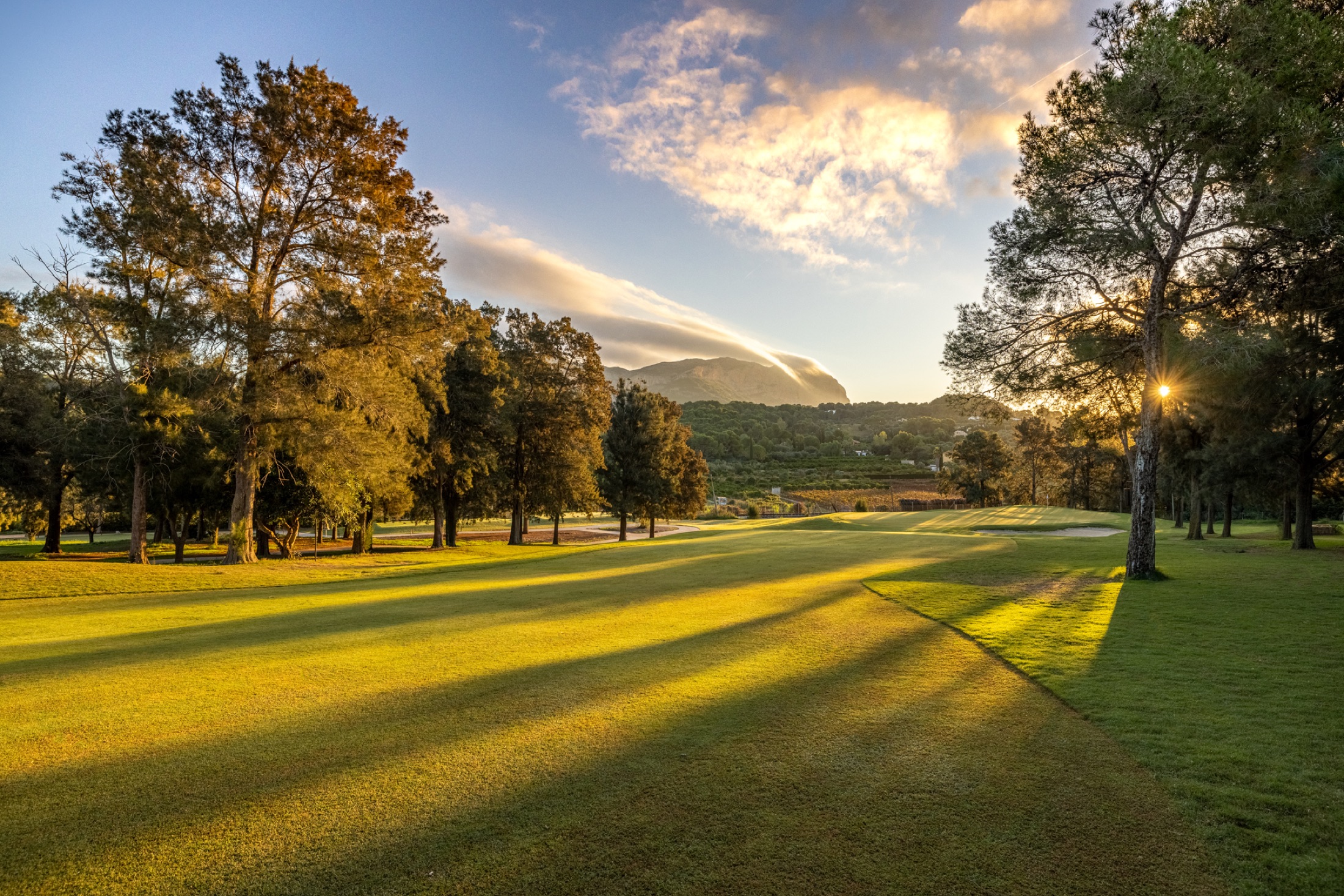 Golden evening light across a tree-lined La Sella Golf fairway
